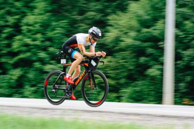 KHARKIV, UKRAINE - 2 Ağustos 2020 Demir Adam yarışması sırasında triatoncu bisikletli triatloncu bisikleti. Üç takım elbiseli ve kasklı bir bisiklet sporcusu. Halka açık etkinliklere izin var. CV salgını sırasında Avrupa sporu.