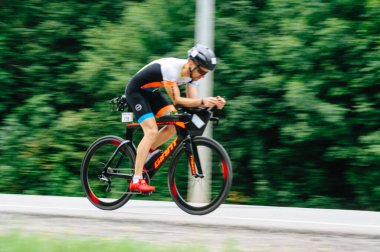 KHARKIV, UKRAINE - 2 Ağustos 2020 Demir Adam yarışması sırasında triatoncu bisikletli triatloncu bisikleti. Üç takım elbiseli ve kasklı bir bisiklet sporcusu. Halka açık etkinliklere izin var. CV salgını sırasında Avrupa sporu.