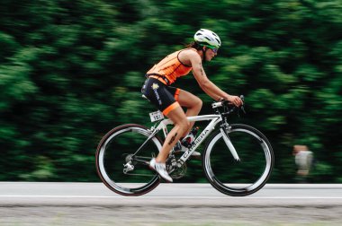 KHARKIV, UKRAINE - 2 Ağustos 2020 Demir Adam yarışması sırasında triatoncu bisikletli triatloncu bisikleti. Üç takım elbiseli ve kasklı bir bisiklet sporcusu. Halka açık etkinliklere izin var. CV salgını sırasında Avrupa sporu.