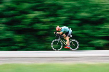 KHARKIV, UKRAINE - 2 Ağustos 2020 Demir Adam yarışması sırasında triatoncu bisikletli triatloncu bisikleti. Üç takım elbiseli ve kasklı bir bisiklet sporcusu. Halka açık etkinliklere izin var. CV salgını sırasında Avrupa sporu.