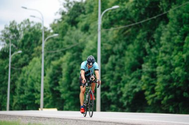 KHARKIV, UKRAINE - 2 Ağustos 2020 Demir Adam yarışması sırasında triatoncu bisikletli triatloncu bisikleti. Üç takım elbiseli ve kasklı bir bisiklet sporcusu. Halka açık etkinliklere izin var. CV salgını sırasında Avrupa sporu.