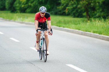 KHARKIV, UKRAINE - 2 Ağustos 2020 Demir Adam yarışması sırasında triatoncu bisikletli triatloncu bisikleti. Üç takım elbiseli ve kasklı bir bisiklet sporcusu. Halka açık etkinliklere izin var. CV salgını sırasında Avrupa sporu.