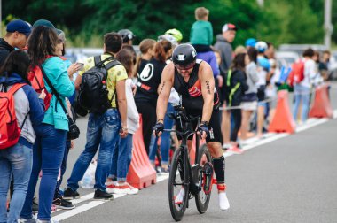 KHARKIV, UKRAINE - 2 Ağustos 2020 Demir Adam yarışması sırasında triatoncu bisikletli triatloncu bisikleti. Üç takım elbiseli ve kasklı bir bisiklet sporcusu. Halka açık etkinliklere izin var. CV salgını sırasında Avrupa sporu.