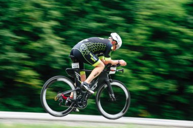 KHARKIV, UKRAINE - 2 Ağustos 2020 Demir Adam yarışması sırasında triatoncu bisikletli triatloncu bisikleti. Üç takım elbiseli ve kasklı bir bisiklet sporcusu. Halka açık etkinliklere izin var. CV salgını sırasında Avrupa sporu.