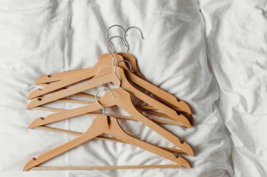 Bir sürü ahşap elbise askısı. Aydınlık zemine bas. Mağaza konsepti, satış, tasarım, boş askı. Metin için yer.