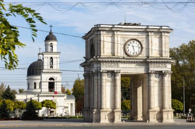 Orta Chisinau 'daki Zafer Kemeri' nin arka planında İsa 'nın Doğumu Katedrali olan saat ve çanları var.