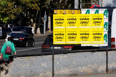 Moldova 'da seçim propagandası panelleriyle sokak görüşü. Kalabalık bir cadde boyunca Chisinau 'da geçen arabalarla dolu bir duvarda büyük sarı seçim posterleri asılı..