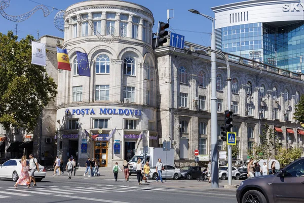 Posta Moldovei tarihi binasında arabalar ve yayalar var. Chisinau şehir merkezinde işlek cadde.