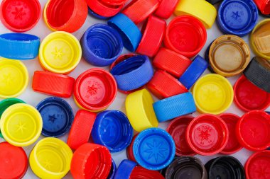 Geri dönüşüm için kullanılan çok renkli plastik kapaklar yığını. Çevresel kavram olarak geri dönüştürülebilir plastik nesneler.