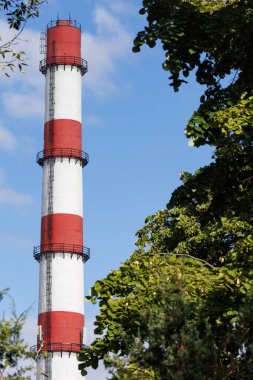 Endüstriyel baca açık mavi gökyüzüne yükseliyor. Kopya alanı ile kirlilik ve endüstri sembolü.