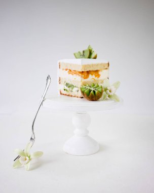 Bisküvi pastasından ile tropikal Kivi Meyve ve beyaz ahşap pasta kürsüye şeftali