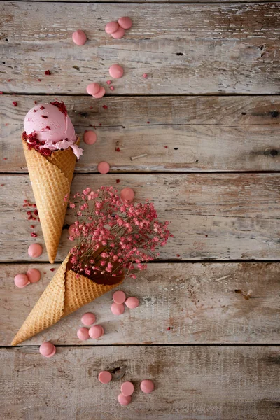 Creamy raspberry ice cream with raspberry berries and pink flowers on vintage wooden background. Top view. Summer mood — Stock Photo, Image