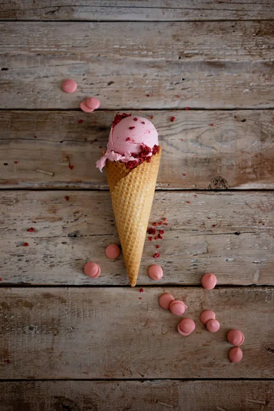 creamy raspberry ice cream with raspberry berries and pink chocolate drops on old fashioned wooden background