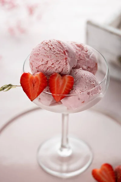 Deliciosas cucharadas de helado de fresa con fresas frescas en forma de corazón sobre fondo rosa. Placa vintage y caja de madera con merengues — Foto de Stock