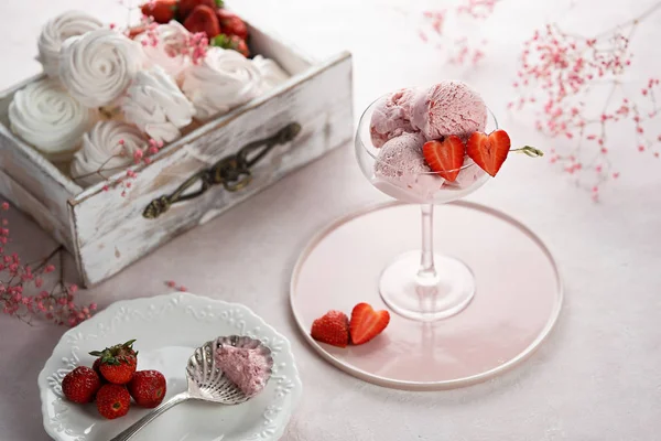 Deliciosas cucharadas de helado de fresa con fresas frescas en forma de corazón sobre fondo rosa. Placa vintage y caja de madera con merengues —  Fotos de Stock