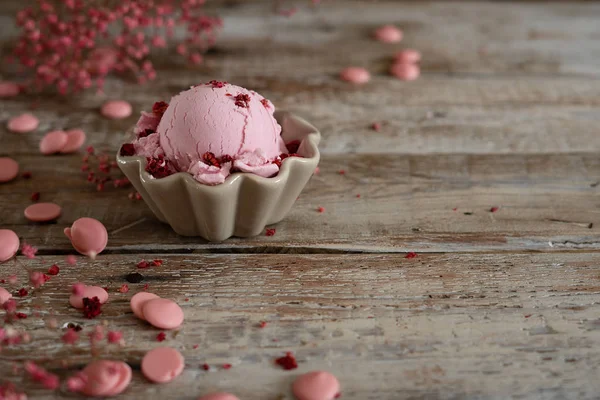 Una cucharada de helado de frambuesa casero en un tazón y gotas de chocolate rosa Fotos de stock libres de derechos