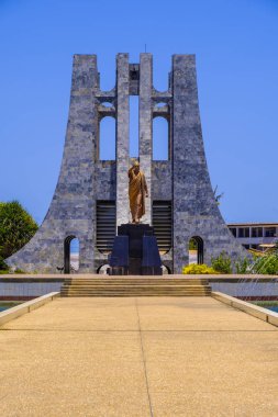 Accra, Gana - 11 Nisan 2018: Kwame Nkrumah Memorial Park'a süslü mermer Türbesi ve açık mavi gökyüzü karşı Ganalı başkana altın heykelini