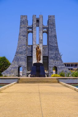 ACCRA,GHANA - APRIL 11 2018: Kwame Nkrumah Memorial Park to the ornate marble Mausoleum and gold statue to the Ghanaian president against clear blue sky clipart