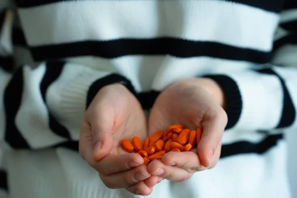 Kırmızı kapsüllü kadın eller. Sağlık, ilaç, vitaminler, ilaç ve sağlık konsepti. 