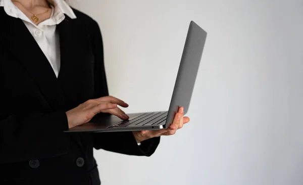 Dizüstü bilgisayarda çalışan siyah elbiseli bir kadın, izole edilmiş bir geçmişi var. İş, dijital, uzaktan çalışma, kurumsal yaşam tarzı. 