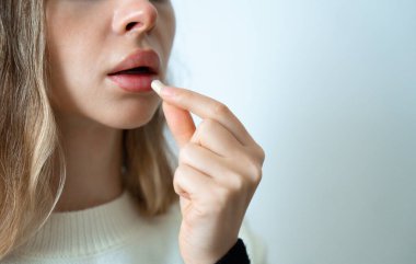 Kadın dudaklarının hap alıp, tıbbı, takviyeleri ve sağlık hizmetlerini simgeleyen yakın plan fotoğrafları.. 