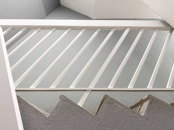 Kıtır gölgeli ve beyaz yüzeyli minimum geometrik merdiven. Modern tasarım ve emlak kavramları için soyut mimari detay. 