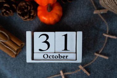 31 Ekim takvim bloklarını küçük balkabakları ve tarçınlarla çevrili kumaşlar üzerine yakın ekin, mevsimsel detaylı çekim.