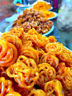 Canlı bir Hint şeker dükkanında tabaklar dolup taşıyor. Yoldan geçenleri tatlı aroması ve göz kamaştırıcı rengiyle cezbediyor..