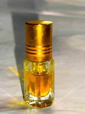 Yüksek çözünürlüklü. Küçük bir kristal şişe altın sıvı özü sergiler Işıl ışıl bir altın kaplama altında, Işıl ışıl beyaz bir yüzey, yumuşak gölgeler dökme.