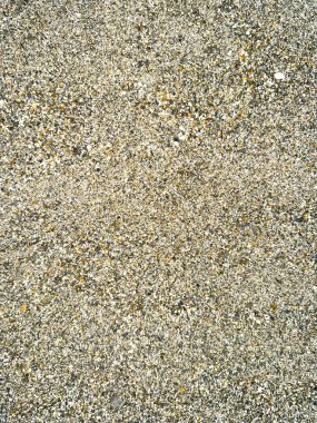 Küçük çakıl taşları ve taşlar parlak güneş ışığı altında detaylı ve ilginç bir desen oluşturur ve yüksek çözünürlüklü bir fotoğraf yaratır..