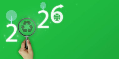 Çevre kavramı, büyüteç geri dönüşüm işaretine odaklı, 2026 yılı, basit ağaç ve küreyle süslenmiş, ok başlıklı ikon, temiz geleceği ve temiz havayı hedefleyen.