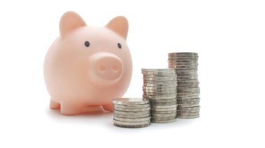 Domuz kumbarası dikey olarak düzenlenmiş paraların yanına yerleştirilmiş. İş, finans, tasarruf kavramı.