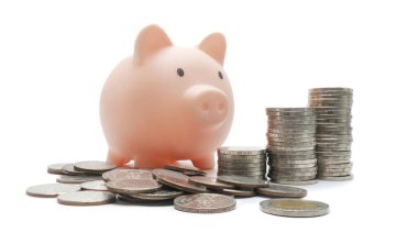 Domuz kumbarası dikey olarak düzenlenmiş paraların yanına yerleştirilmiş. İş, finans, tasarruf kavramı.