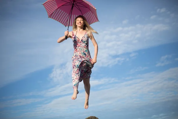 Joven atractiva mujer feliz saltando en el cielo con paraguas — Foto de Stock