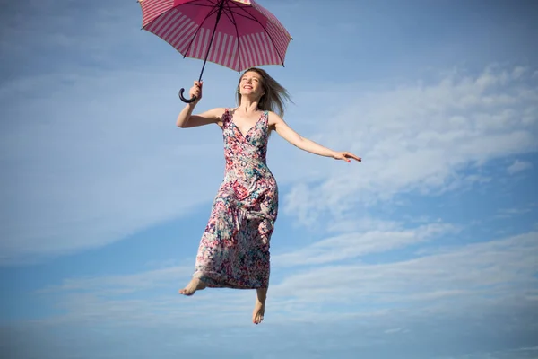 Concept pure happiness young female holding umbrelle flying in sky — Stock Photo, Image