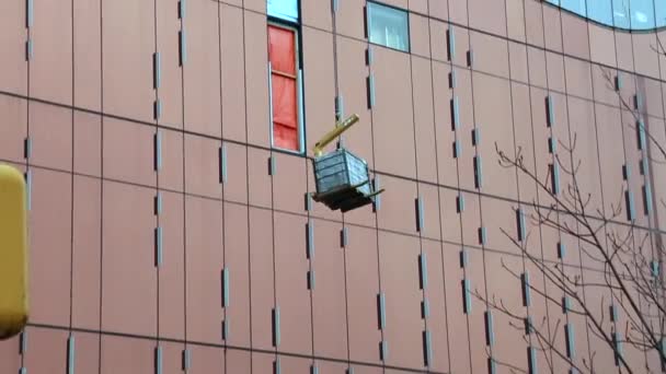 Construction grue levage charge façade bâtiment moderne — Video