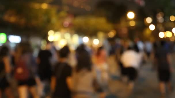 Натовп одноманітних людей, що ходять літнім нічним містом — стокове відео