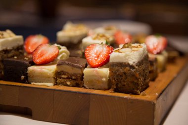 Pasta çeşitli çikolata kek dilimleri ahşap tepsi çilek arka plan 