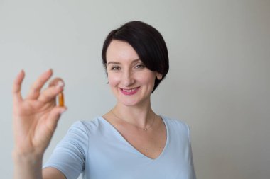 Turuncu hapları tutan kadın portre dikey çekim el