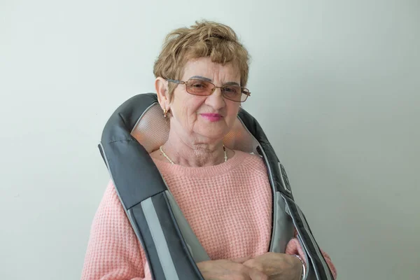 Elderly caucasian woman massager device shoulders portrait Royalty Free Stock Photos