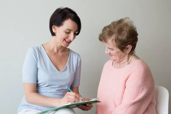 Elderly female answering questions doctor appointment Stock Photo