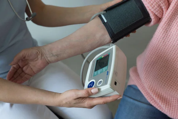 Yakın çekim kan basıncı yaşlı kadın silah eller ölçülen 
