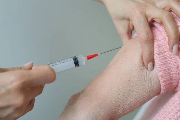 Closeup elderly woman injection syringe hands caregiver Stock Image