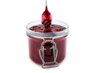 Beyaz bir arka plan üzerine bir kaşık Frenk üzümü reçeli