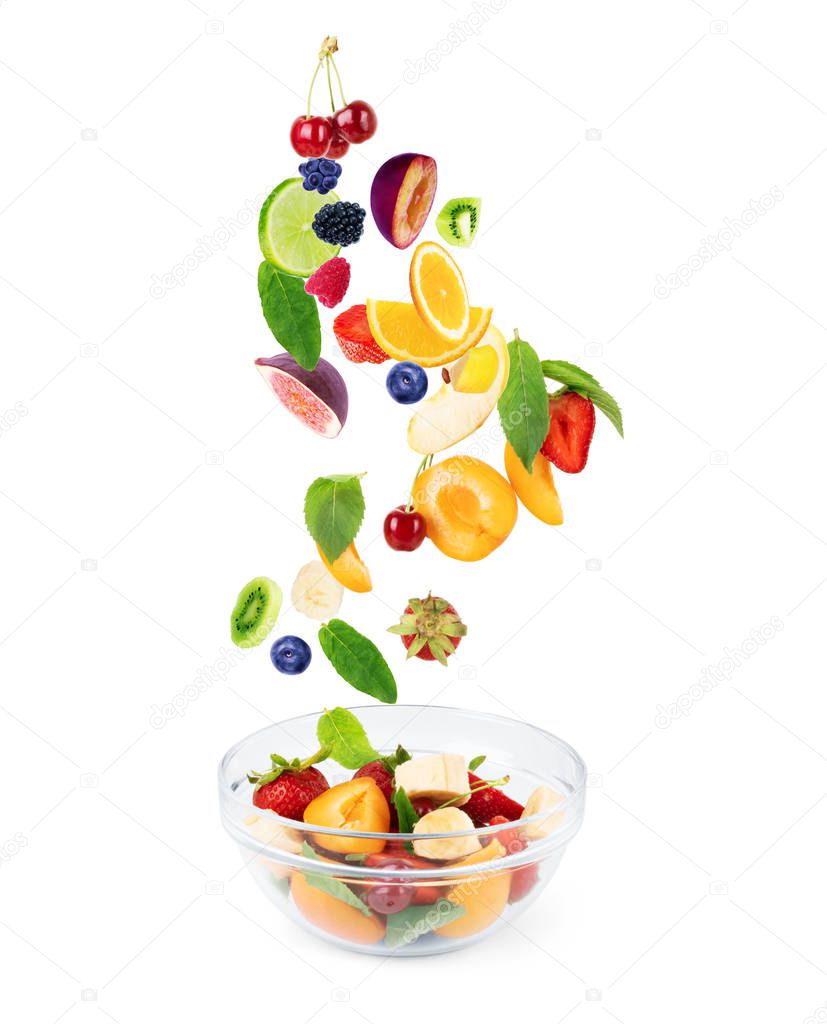 different fruits, in flight fly into a plate with fruit, on a wh