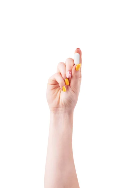 Main de femme avec une pilule sur fond blanc — Photo