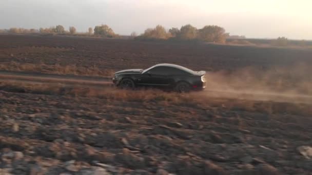 4k vista aérea passeios de carro esporte na estrada de campo empoeirado — Vídeo de Stock