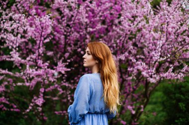 Bahar zamanında güzel rüya kızıl kadın çiçek kiraz ağaçları bahçe.