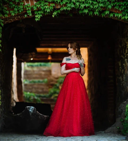 Donna rossa in abito rosso vicino al castello — Foto Stock