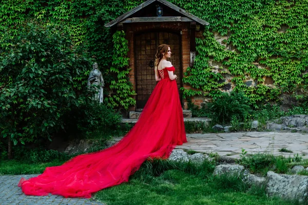 Donna rossa in abito rosso vicino al castello — Foto Stock